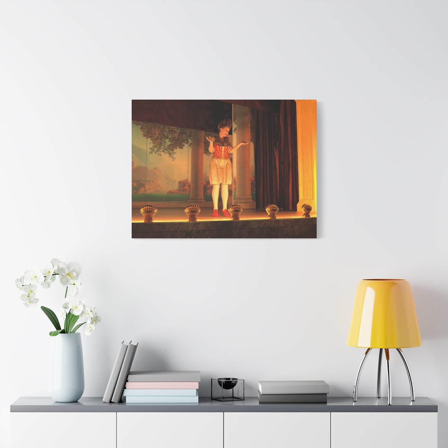 A framed wall art print depicting a classical painting of a child on a stage, displayed on a white wall above a console table with a yellow lamp, books, and a vase of white flowers.