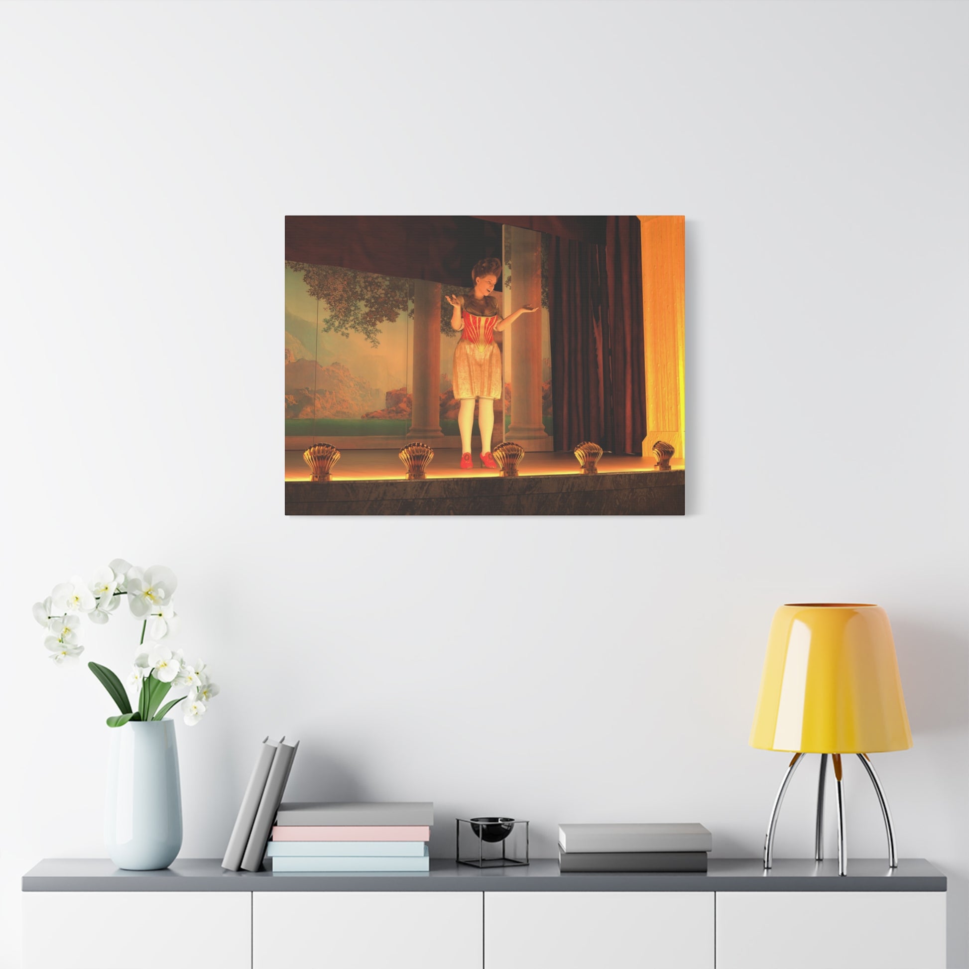 A framed wall art print depicting a classical painting of a child on a stage, displayed on a white wall above a console table with a yellow lamp, books, and a vase of white flowers.